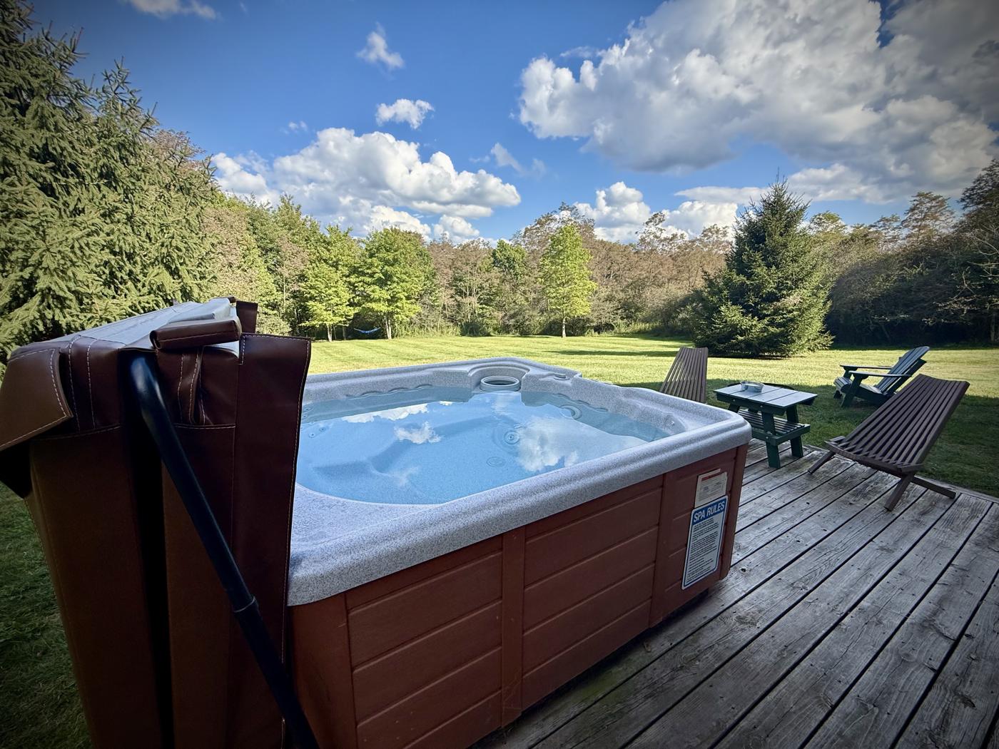 Hot tub on the back deck overlooking a wide green yard